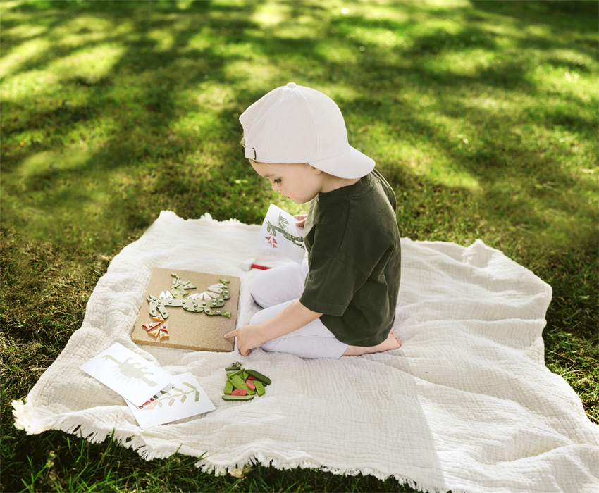 Child hammering wooden shapes cork board