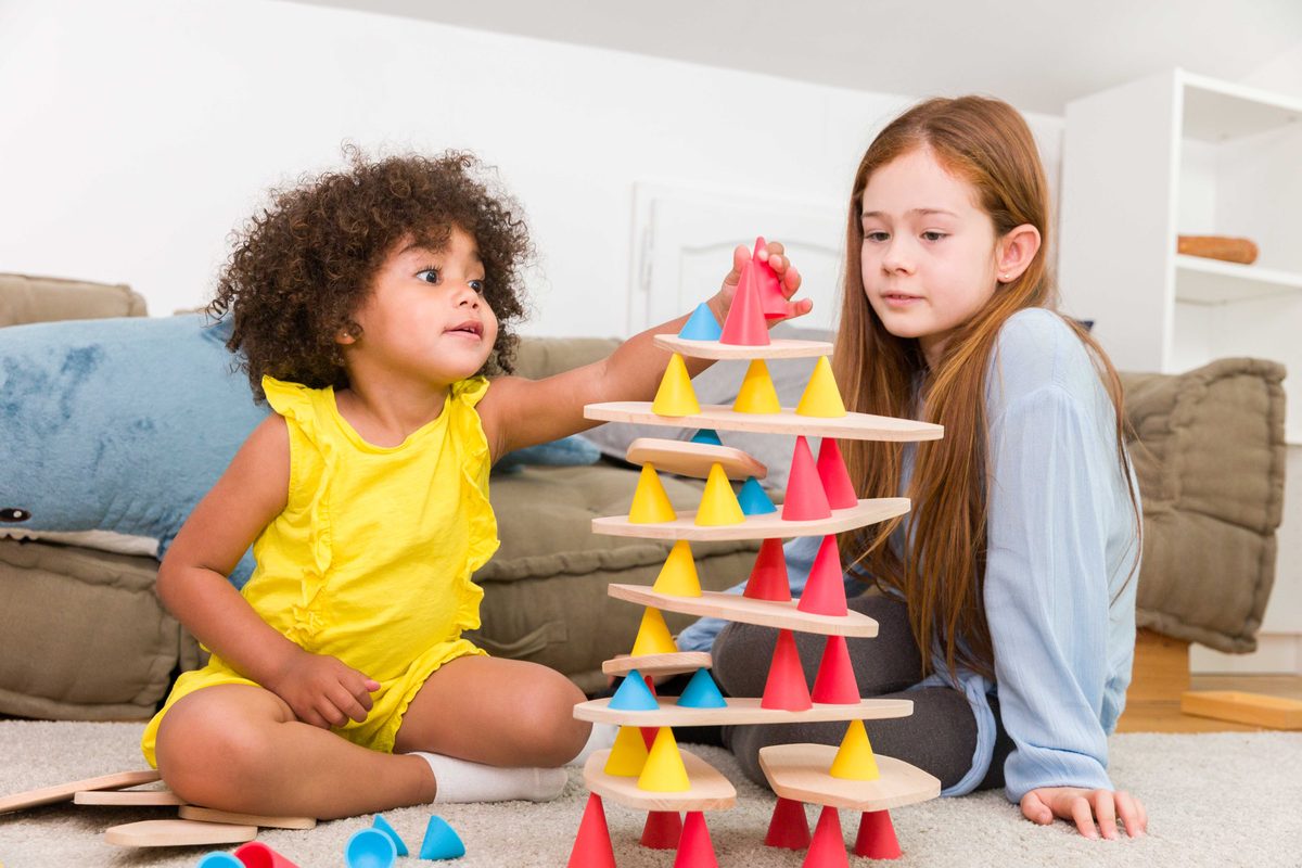 Bambino che costruisce una torre in equilibrio con Piks